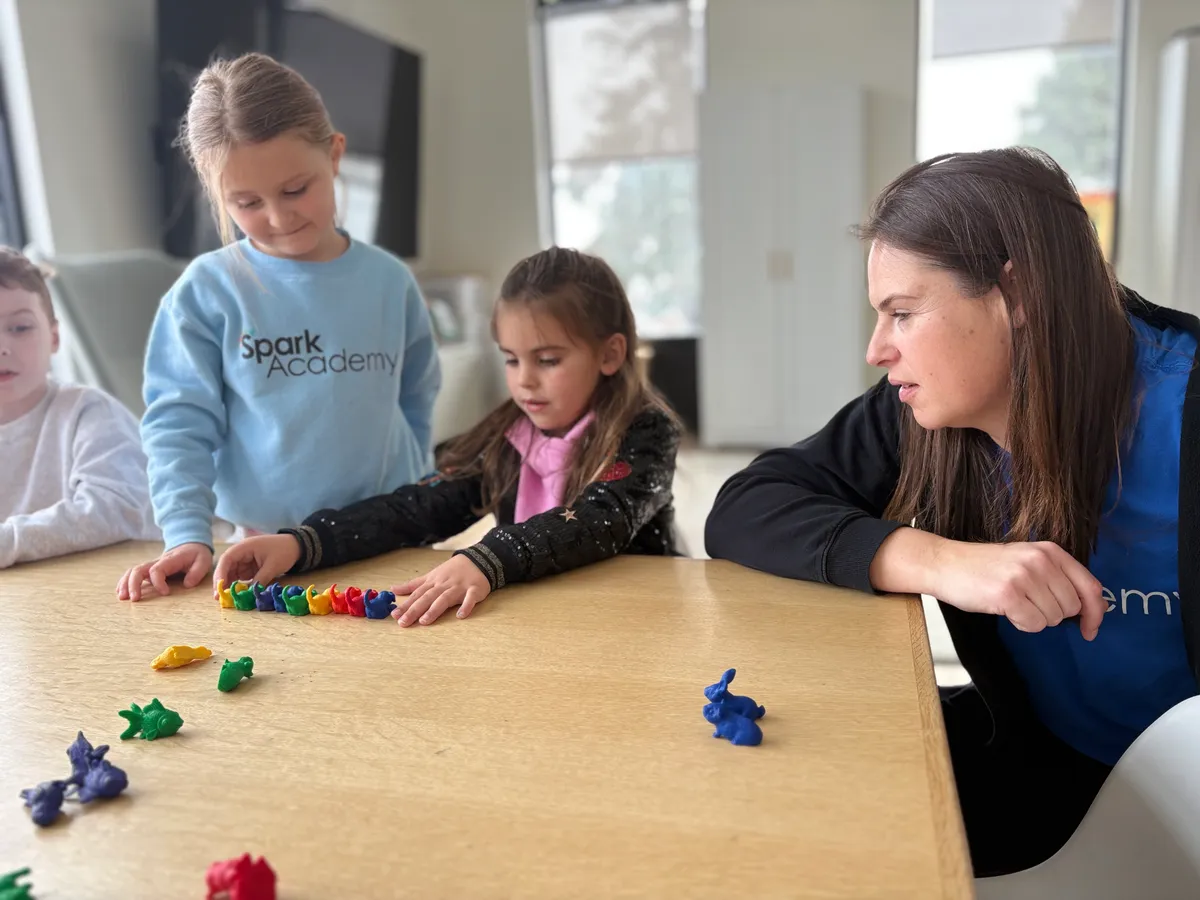 Spark Academy teacher working one-on-one with students using counting manipulatives